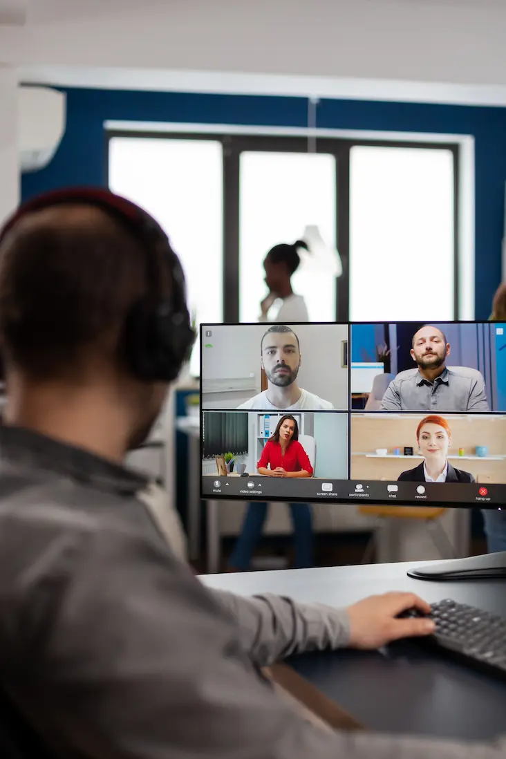 Dedicated remote IT team collaborating around a laptop in a modern office